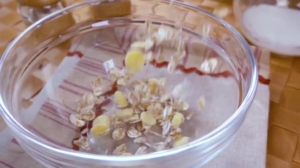 Muesli de céréales à grains entiers dans un bol pour un délicieux petit déjeuner matinal avec du lait. Mouvement lent avec tir de suivi de rotation . — Video