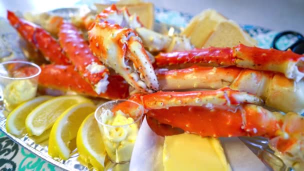 Patas de cangrejo rey rojo con rodajas de limón fresco. Delicioso menú de mariscos y restaurantes de lujo. — Vídeo de stock