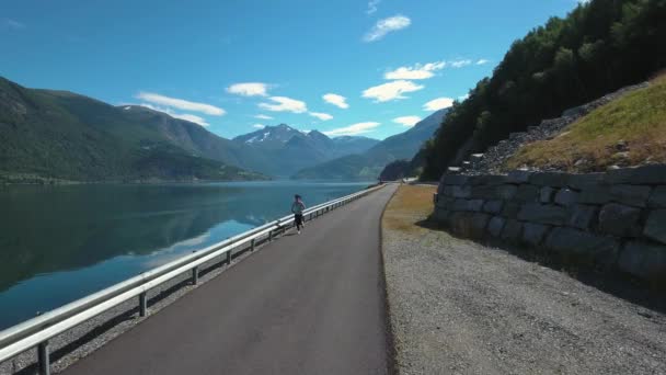 Een vrouw die buiten jogt. Noorse fjord. — Stockvideo