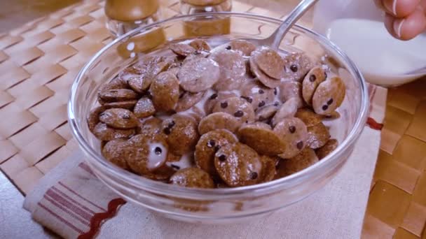 Křupavé čokoládové vločky v misce na ranní lahodnou snídani s mlékem. Zpomalený pohyb se snímkem sledování otáčení. — Stock video
