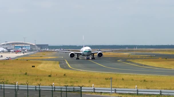 Тягач буксирует пассажирский самолет на взлетно-посадочную полосу аэродрома — стоковое видео