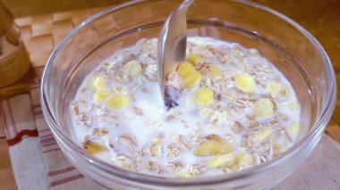 Sabah kahvaltısı için bir kâsede tam tahıllı müsli. Sütlü. Döndürme izleyici çekimi ile yavaş çekim.