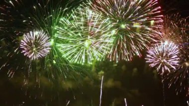 Gece gökyüzünde renkli havai fişekler patlıyor. Kutlamalar ve olaylar parlak renklerle.