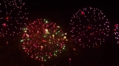 Gece gökyüzünde renkli havai fişekler patlıyor. Kutlamalar ve olaylar parlak renklerle.