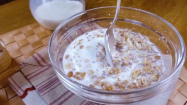 Sabah kahvaltısı için bir kâsede tam tahıllı müsli. Sütlü. Döndürme izleyici çekimi ile yavaş çekim.