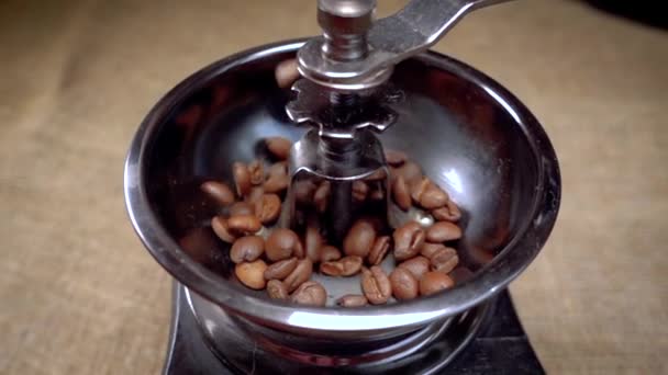 Grãos de café caem no moedor velho. Movimento lento com tiro de rastreamento de rotação . — Vídeo de Stock