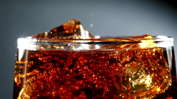 Cola con hielo y burbujas en vidrio . — Vídeos de Stock