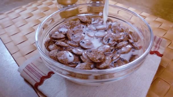 Flocons de chocolat croustillants dans un bol pour un délicieux petit déjeuner matinal avec du lait. Mouvement lent avec tir de suivi de rotation . — Video