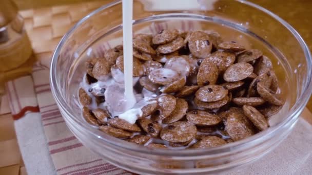 Flocos de chocolate crocante em uma tigela para um delicioso café da manhã com leite. Movimento lento com tiro de rastreamento de rotação . — Vídeo de Stock