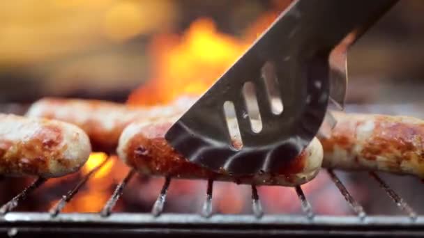 Deliciosas salsichas suculentas, cozidas na grelha com fogo — Vídeo de Stock
