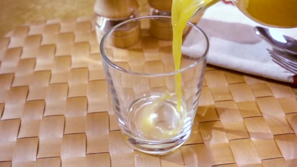 El jugo de naranja vertiendo en un vaso, el desayuno de la mañana. Movimiento lento con disparo de seguimiento de rotación . — Vídeos de Stock