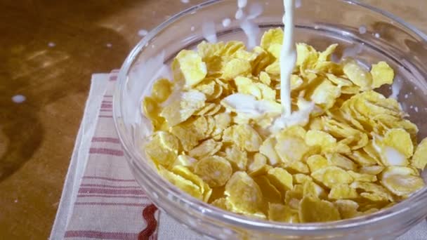 Хрусткі жовті кукурудзяні пластівці в миску на ранок смачний сніданок з молоком. Повільний рух з пострілом відстеження обертання . — стокове відео