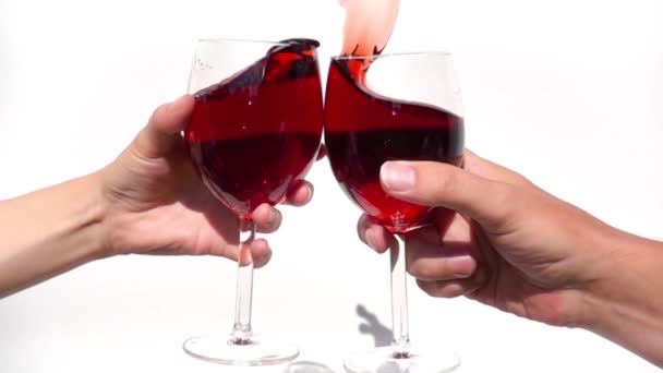 Kadeh kaldıran iki el beyaz arka planda ağır çekimde cam kırmızı şarap. — Stok video