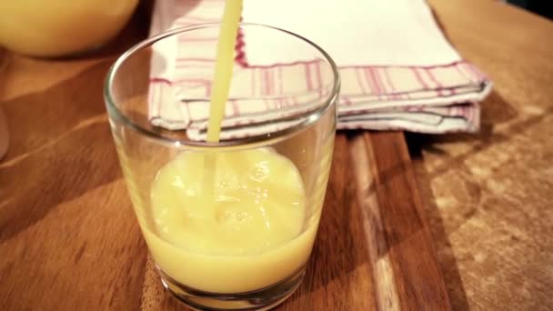 Sinaasappelsap gieten in een glas, de ochtend ontbijt. Trage beweging met rotatie tracking shot. — Stockvideo