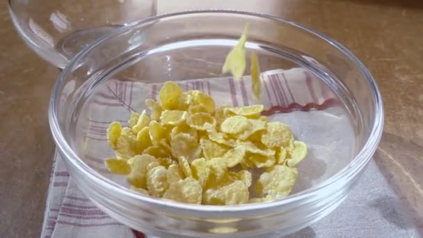 Crujientes copos de maíz amarillo en el tazón para la mañana un delicioso desayuno con leche. Movimiento lento con disparo de seguimiento de rotación . — Vídeos de Stock