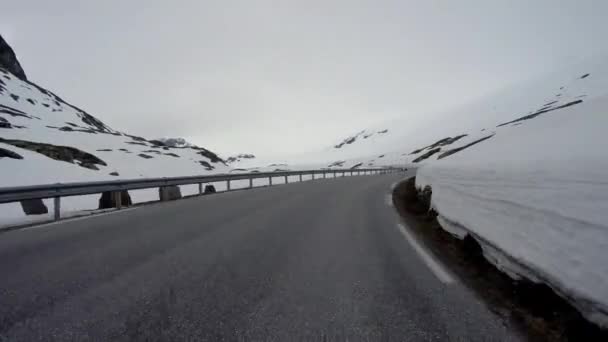 Condução de um carro em uma estrada de montanha na Noruega com parede de neve alta — Vídeo de Stock