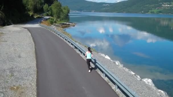 Een vrouw die buiten jogt. Noorse fjord. — Stockvideo