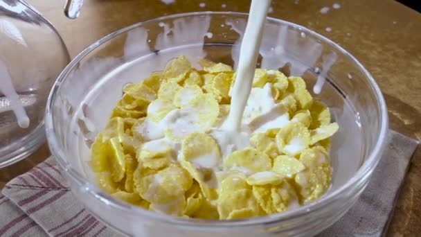 Crispy yellow corn flakes into the bowl for the morning a delicious Breakfast with milk. Slow motion with rotation tracking shot. — Stock Video