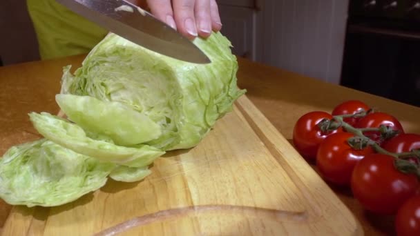 Mes snijdt salade, sla op houten plank Slow motion met rotatie tracking shot. — Stockvideo