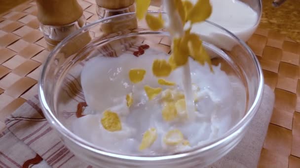 Хрустящие желтые хлопья кукурузы в миску на утро вкусный завтрак с молоком. Медленное движение с отслеживанием вращения снимка . — стоковое видео