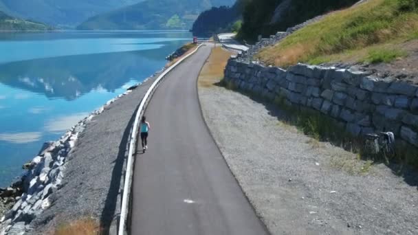 Žena běhá venku zpomaleně. Norský fjord. — Stock video