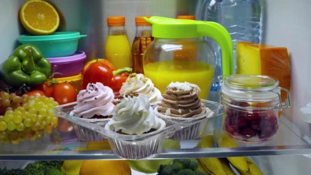Édes sütemények a nyitott hűtőben. Hűtőszekrényben lévő termékek. — Stock videók