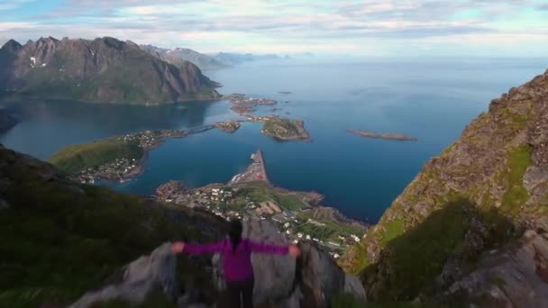 Wandelaar vrouw staat met handen omhoog het bereiken van de top. Lofoten is een plaats in de Noorse gemeente Nordland, provincie Nordland.. — Stockvideo