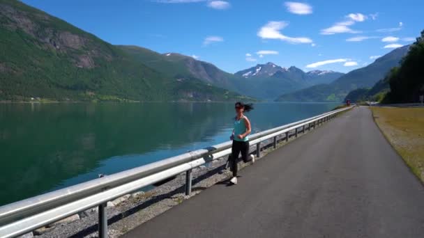 Een vrouw die buiten jogt. Noorse fjord. — Stockvideo