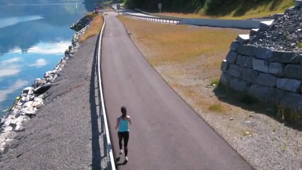 Mujer corriendo al aire libre. Fiordo noruego . — Vídeo de stock