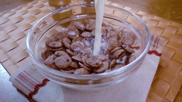 Ropogós csokipelyhek egy tálban egy reggeli finom reggelit tejjel. Lassú mozgás forgásnyomkövető lövéssel. — Stock videók
