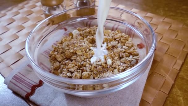 Teljes kiőrlésű gabonapehely müzli egy tálban egy reggeli ízletes reggeli tejjel. Lassú mozgás forgásnyomkövető lövéssel. — Stock videók