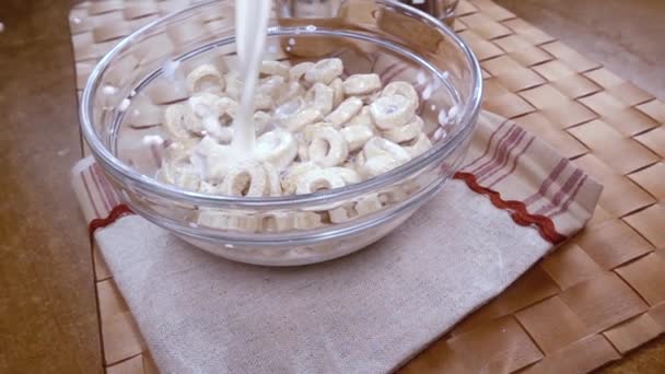 Knusprige Haferflocken in einer Schüssel für ein köstliches Frühstück mit Milch am Morgen. Zeitlupe mit Drehverfolgungsschuss. — Stockvideo