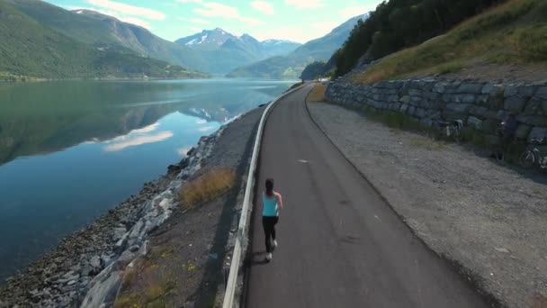 Žena běhá venku. Norský fjord. — Stock video