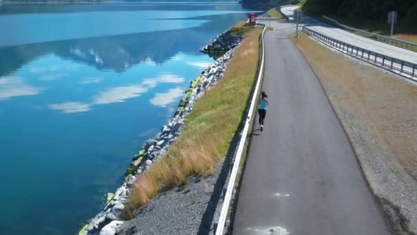 Mujer corriendo al aire libre. Fiordo noruego . — Vídeo de stock