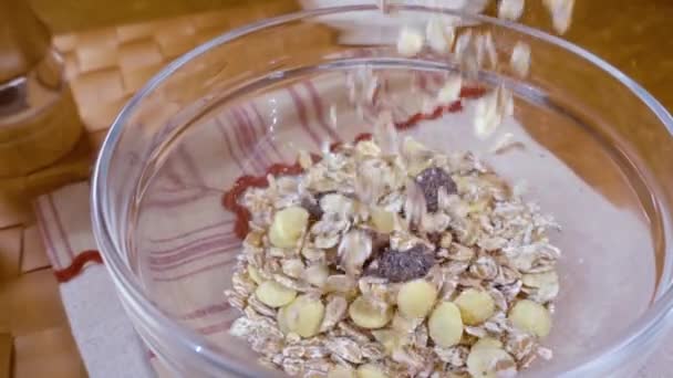 Muesli de céréales à grains entiers dans un bol pour un délicieux petit déjeuner matinal avec du lait. Mouvement lent avec tir de suivi de rotation . — Video