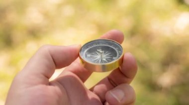 Gezgin el ormanda bir pusula tutuyor.