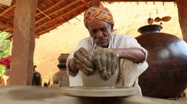 Potter iş yerinde seramik yemekler yapıyor. Hindistan, Rajasthan.