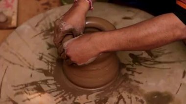 Potter iş yerinde seramik yemekler yapıyor. Hindistan, Rajasthan.