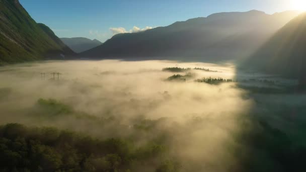 Ranní mlha nad údolím mezi horami ve slunečním světle. Mlha a krásná příroda norského leteckého záběru. — Stock video
