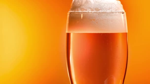 Легкое пиво оседает в стакане с белой крышкой из пены — стоковое видео