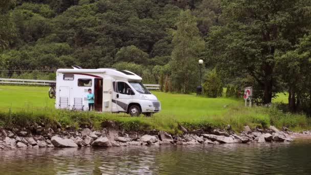 Kvinna står med en mugg kaffe nära husbilen RV. — Stockvideo