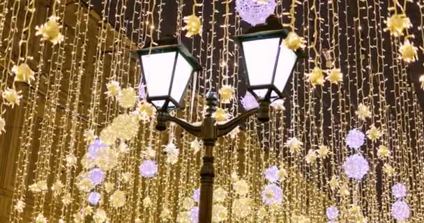 Farol de calle con guirnaldas navideñas decorativas. Año nuevo y celebración de Navidad. — Vídeo de stock