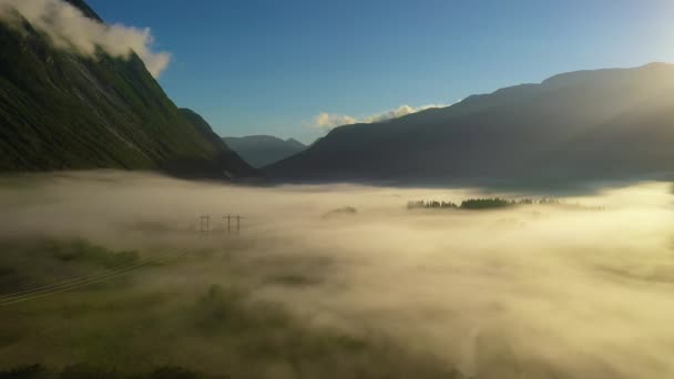 Niebla de la mañana sobre el valle entre las montañas a la luz del sol. Niebla y hermosa naturaleza de Noruega imágenes aéreas. — Vídeos de Stock