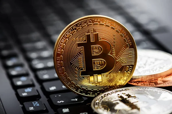 Foto Bitcoins dourados no teclado notebook — Fotografia de Stock