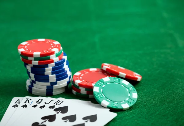 Casino yeşil masa yongaları ve oyun kartları ile