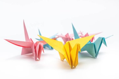 Origami kuşları beyaz arka planda akın eder. Liderlik kavramı