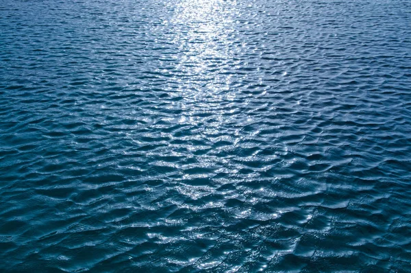 Superfície da água com reflexão do brilho do sol — Fotografia de Stock