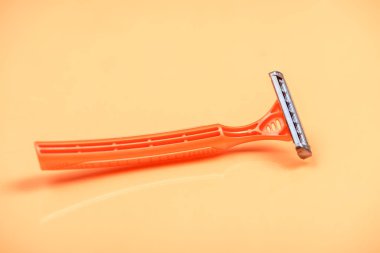 Pastel renk arkaplanında tek kullanımlık tıraş makinesi