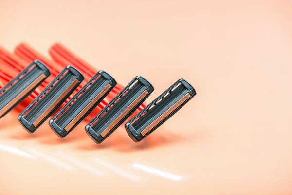 Group of red safety razors on orange color background 스톡 이미지