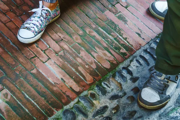 Gambe di uomo e donna in scarpe sportive e in piedi su una strada di città in Italia — Foto Stock